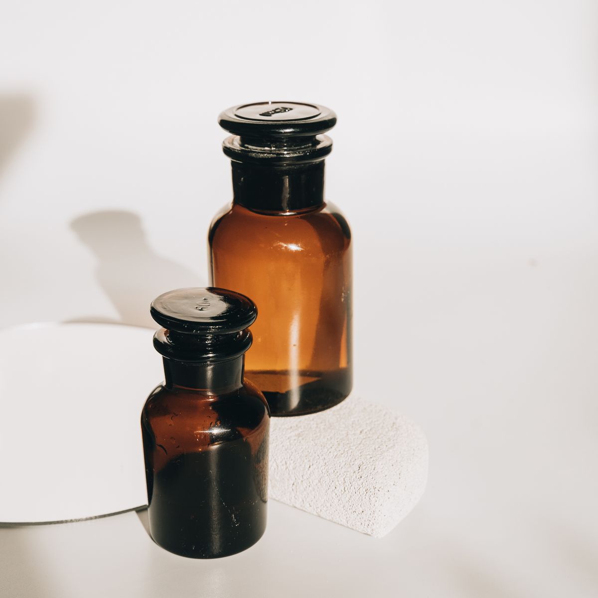 Two amber glass apothecary bottles in warm window light